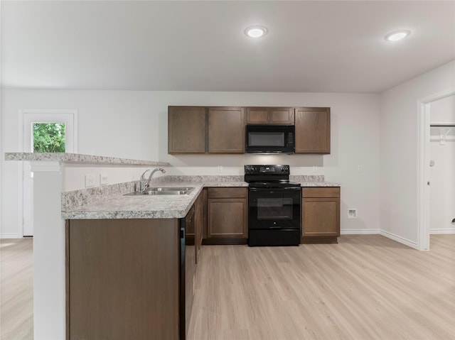 306 N Orange St, Sweeny, TX 77480 - kitchen featuring black appliances, light countertops, light wood finished floors, recessed lighting, and dark brown cabinetry