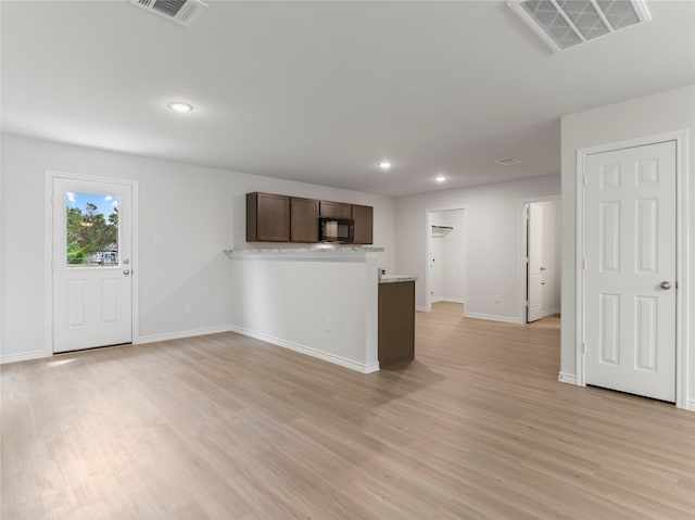 306 N Orange St, Sweeny, TX 77480 - kitchen featuring black microwave, light wood-type flooring, dark brown cabinetry, recessed lighting, and a peninsula