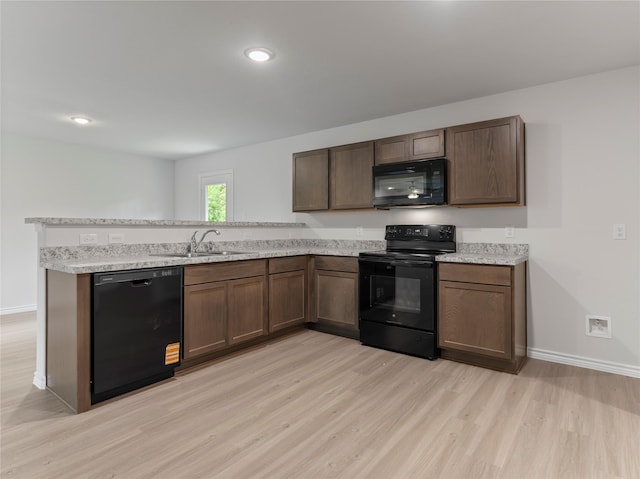 306 N Orange St, Sweeny, TX 77480 - kitchen featuring black appliances, light wood-type flooring, a peninsula, light countertops, and recessed lighting