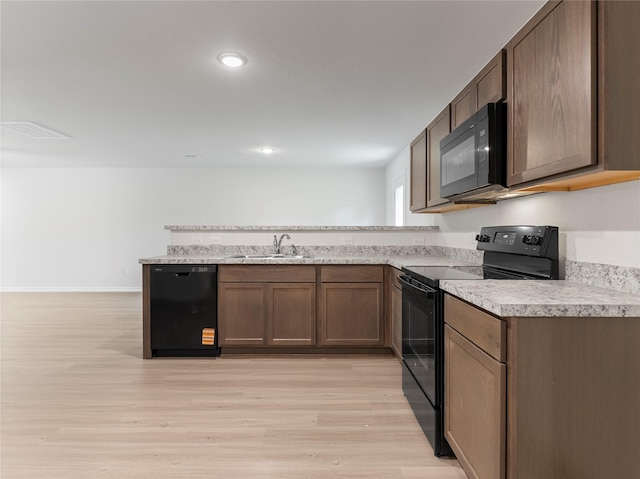 306 N Orange St, Sweeny, TX 77480 - kitchen featuring black appliances, light countertops, a peninsula, light wood finished floors, and recessed lighting