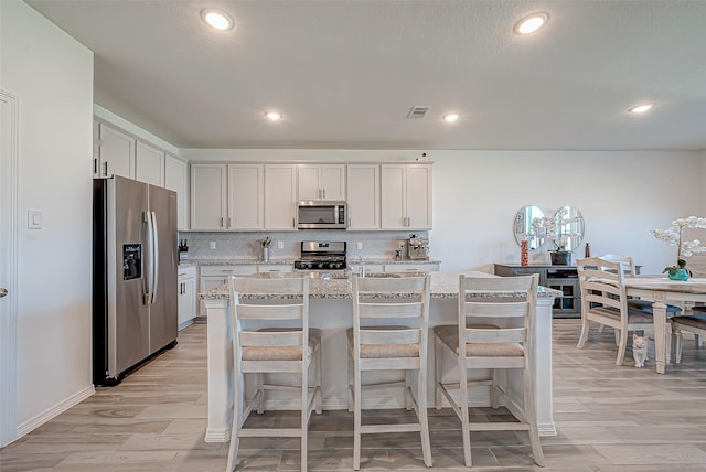 5703 Morning Vista Rd, Katy, TX 77493 - kitchen with appliances with stainless steel finishes, light wood-style floors, light stone countertops, tasteful backsplash, and recessed lighting