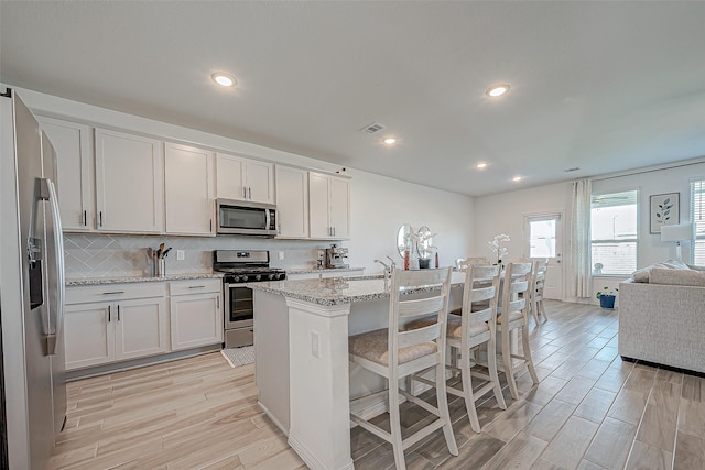 5703 Morning Vista Rd, Katy, TX 77493 - kitchen with stainless steel appliances, light wood-style floors, light stone counters, recessed lighting, and open floor plan