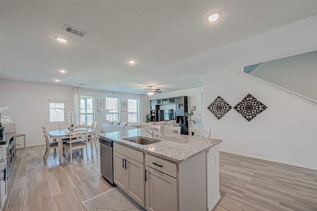 5703 Morning Vista Rd, Katy, TX 77493 - kitchen with dishwasher, light wood-style floors, a kitchen island with sink, light stone countertops, and recessed lighting