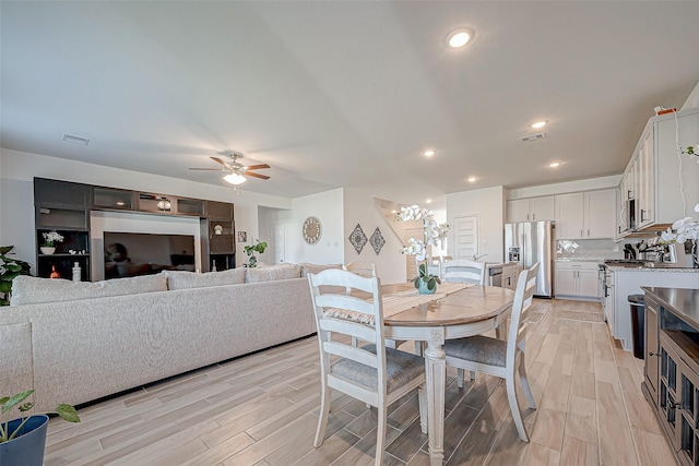 5703 Morning Vista Rd, Katy, TX 77493 - dining space featuring light wood-style flooring, a ceiling fan, a chandelier, and recessed lighting