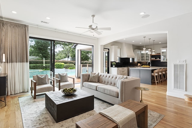 919 Worthshire St, Houston, TX 77008 - living area featuring ceiling fan, light wood finished floors, recessed lighting, and arched walkways