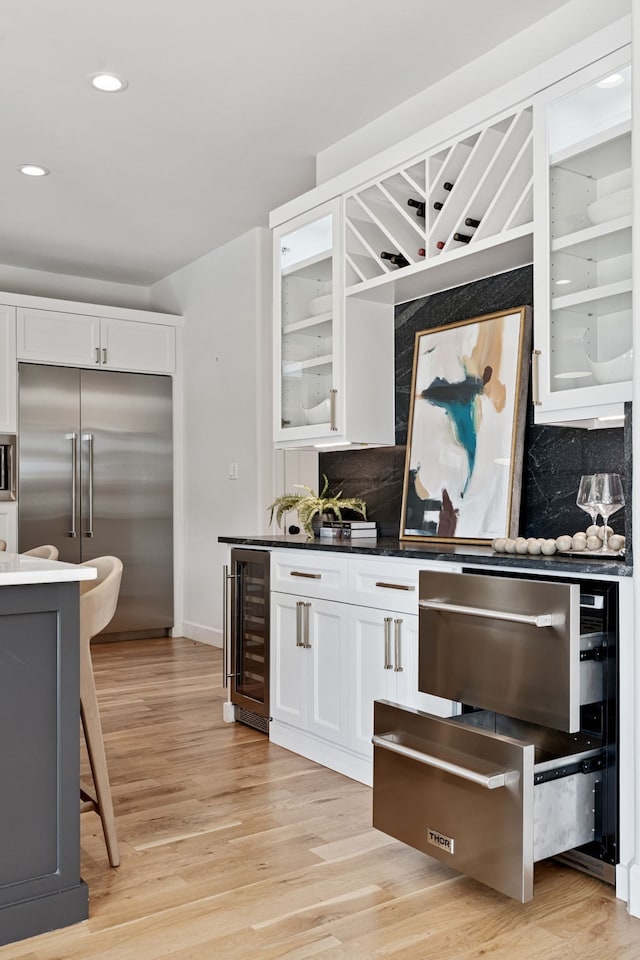 919 Worthshire St, Houston, TX 77008 - kitchen with wine cooler, built in refrigerator, glass insert cabinets, white cabinetry, and recessed lighting