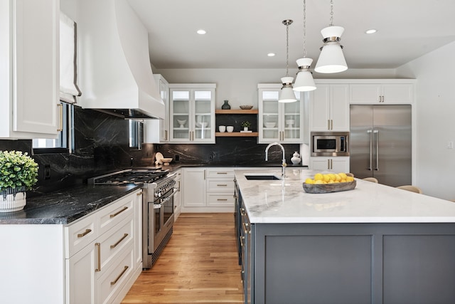 919 Worthshire St, Houston, TX 77008 - kitchen featuring built in appliances, custom exhaust hood, white cabinetry, a center island with sink, and recessed lighting