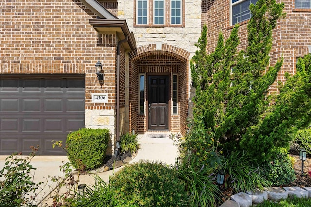 4306 Dalea Clover Ln, Manvel, TX 77578 - view of exterior entry with brick siding, stone siding, and a garage