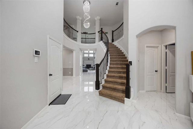 4306 Dalea Clover Ln, Manvel, TX 77578 - foyer with marble tiled floors, stairs, a chandelier, a high ceiling, and arched walkways