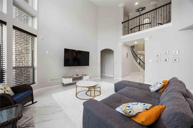 4306 Dalea Clover Ln, Manvel, TX 77578 - living area featuring marble tiled flooring, decorative columns, stairs, a high ceiling, and arched walkways