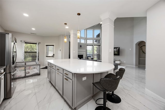 4306 Dalea Clover Ln, Manvel, TX 77578 - kitchen featuring gray cabinetry, freestanding refrigerator, light marble finish flooring, a fireplace, and a center island