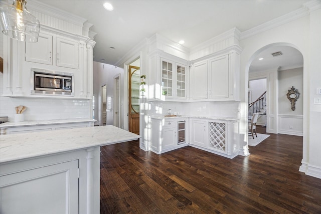106 Melody Ln, Friendswood, TX 77546 - kitchen with stainless steel microwave, beverage cooler, white cabinetry, crown molding, and recessed lighting