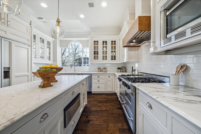 106 Melody Ln, Friendswood, TX 77546 - kitchen featuring appliances with stainless steel finishes, a warming drawer, wall chimney range hood, crown molding, and dark wood finished floors
