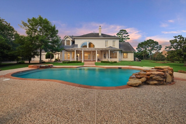 106 Melody Ln, Friendswood, TX 77546 - pool at dusk featuring a pool with connected hot tub, a yard, and a patio