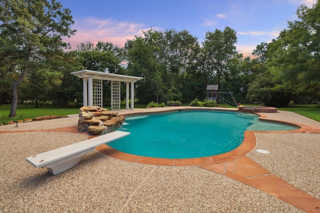 106 Melody Ln, Friendswood, TX 77546 - pool at dusk featuring a diving board, a pool with connected hot tub, view of wooded area, and a patio area