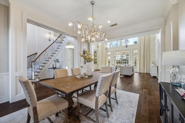 106 Melody Ln, Friendswood, TX 77546 - dining space featuring stairs, wood-type flooring, arched walkways, crown molding, and a chandelier