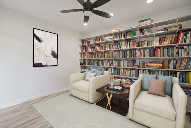 4018 Shady Springs Dr, Seabrook, TX 77586 - sitting room with wall of books, ceiling fan, wood finished floors, and recessed lighting