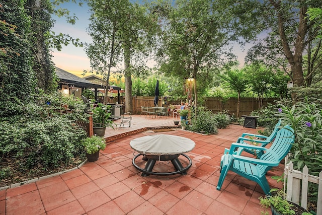 4018 Shady Springs Dr, Seabrook, TX 77586 - patio terrace at dusk featuring a gazebo, a deck, an outdoor fire pit, and a patio