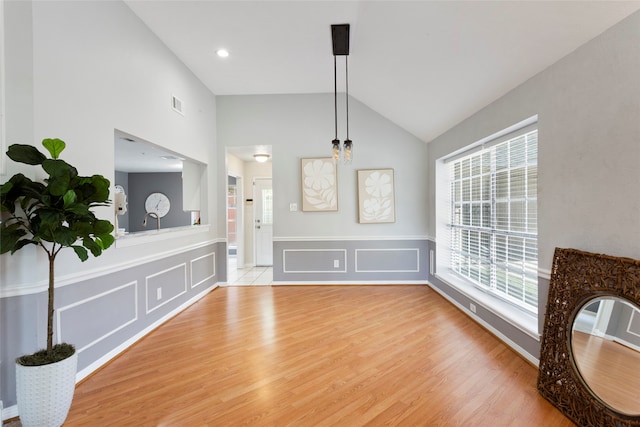 4311 Pebble Beach Dr, League City, TX 77573 - unfurnished dining area featuring a decorative wall, light wood-style floors, wainscoting, and high vaulted ceiling