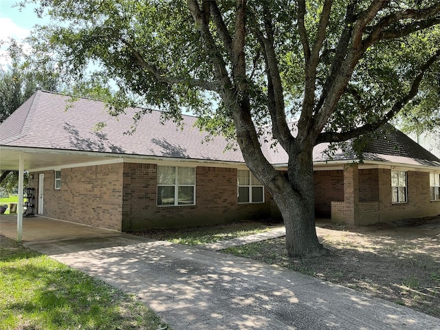30 Piper Ln, Normangee, TX 77871 - view of side of home with an attached carport, brick siding, and driveway