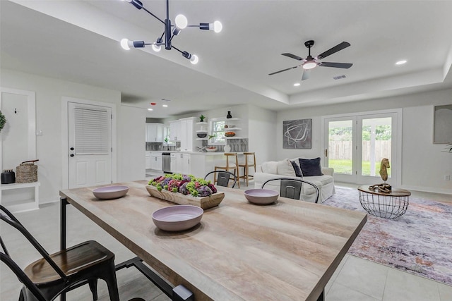 5226 Sanford Rd, Houston, TX 77035 - dining space with a tray ceiling, ceiling fan, light tile patterned floors, recessed lighting, and a chandelier