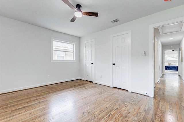 5226 Sanford Rd, Houston, TX 77035 - unfurnished bedroom featuring attic access, multiple windows, light wood-type flooring, and multiple closets