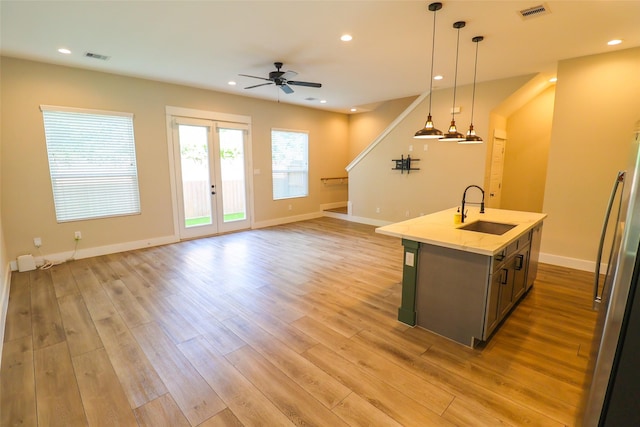 5213 Pinemont Creek Ln, Houston, TX 77018 - kitchen featuring a ceiling fan, open floor plan, light wood-style floors, a center island with sink, and pendant lighting