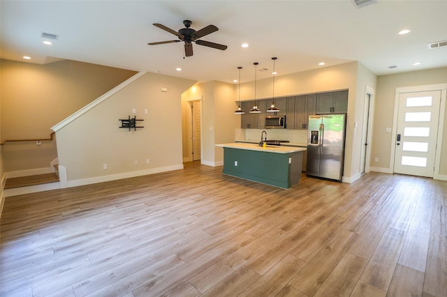 5213 Pinemont Creek Ln, Houston, TX 77018 - kitchen featuring stainless steel appliances, light countertops, open floor plan, a center island with sink, and ceiling fan