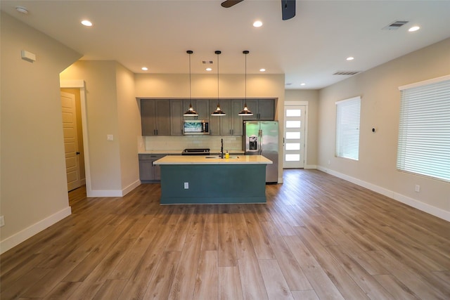 5213 Pinemont Creek Ln, Houston, TX 77018 - kitchen featuring stainless steel appliances, light countertops, ceiling fan, light wood finished floors, and tasteful backsplash
