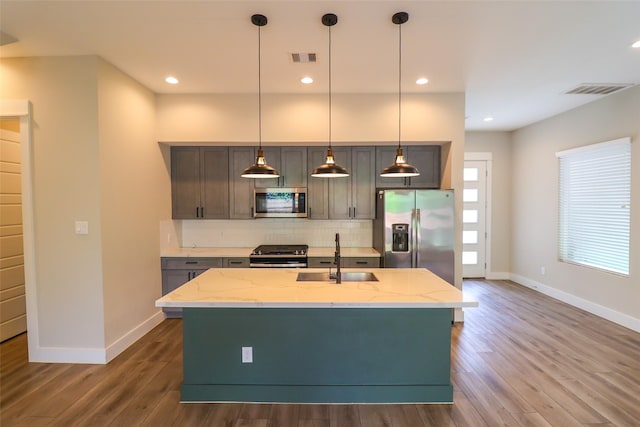 5213 Pinemont Creek Ln, Houston, TX 77018 - kitchen with stainless steel appliances, tasteful backsplash, wood finished floors, light stone counters, and recessed lighting