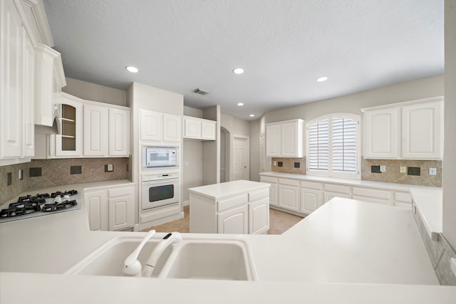 16426 Torry View Ter, Houston, TX 77095 - kitchen with white appliances, backsplash, recessed lighting, glass insert cabinets, and light tile patterned floors