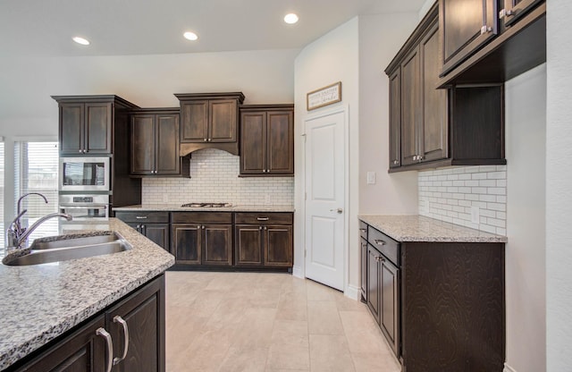 3605 Dolan Trail Ct, Pearland, TX 77584 - kitchen featuring stainless steel appliances, dark brown cabinets, decorative backsplash, recessed lighting, and light stone countertops