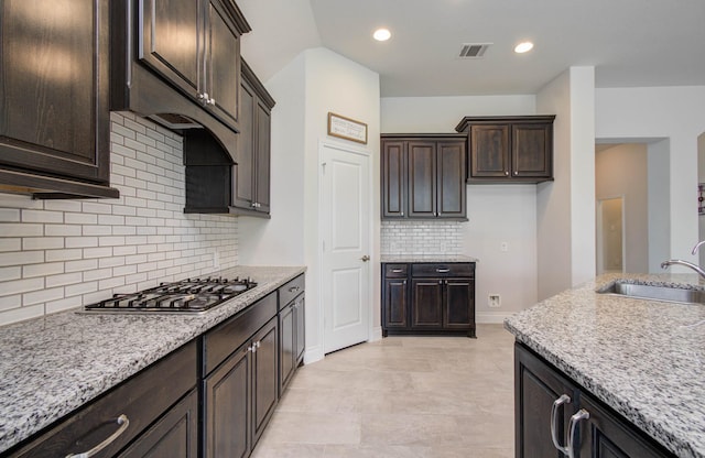 3605 Dolan Trail Ct, Pearland, TX 77584 - kitchen featuring stainless steel gas stovetop, dark brown cabinets, tasteful backsplash, light stone countertops, and recessed lighting