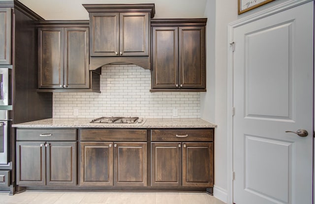 3605 Dolan Trail Ct, Pearland, TX 77584 - kitchen featuring decorative backsplash, dark brown cabinets, and light stone counters