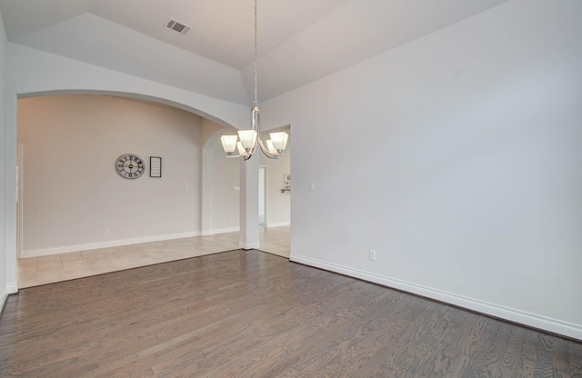 3605 Dolan Trail Ct, Pearland, TX 77584 - empty room featuring a chandelier, arched walkways, wood finished floors, and vaulted ceiling