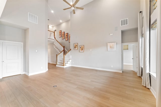 14315 Summer Prairie Trl, Cypress, TX 77433 - unfurnished living room with a towering ceiling, a ceiling fan, stairs, and light wood-style floors