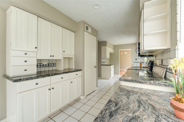 15403 Meadow Village Dr, Houston, TX 77095 - kitchen featuring stove, light tile patterned floors, decorative backsplash, dark stone counters, and open shelves