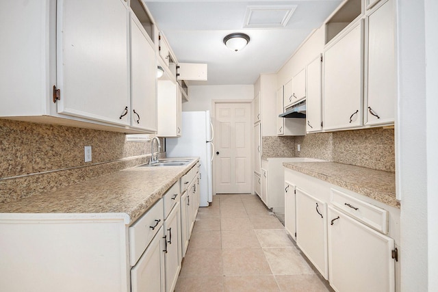 1605 30th St N, Texas City, TX 77590 - kitchen with under cabinet range hood, freestanding refrigerator, tasteful backsplash, light tile patterned floors, and light countertops