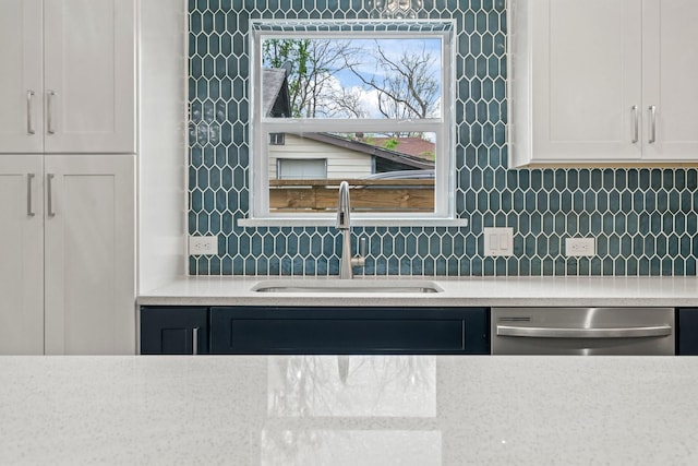 1009 Genova St, Houston, TX 77009 - kitchen with dishwasher, decorative backsplash, and white cabinets
