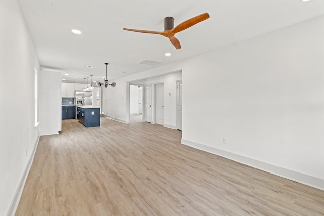 1009 Genova St, Houston, TX 77009 - unfurnished living room with light wood-style flooring, ceiling fan, a chandelier, and recessed lighting