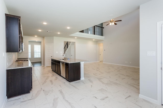 8506 Belfast Manor Ln, Richmond, TX 77407 - kitchen featuring stainless steel appliances, a ceiling fan, dark brown cabinets, open floor plan, and an island with sink