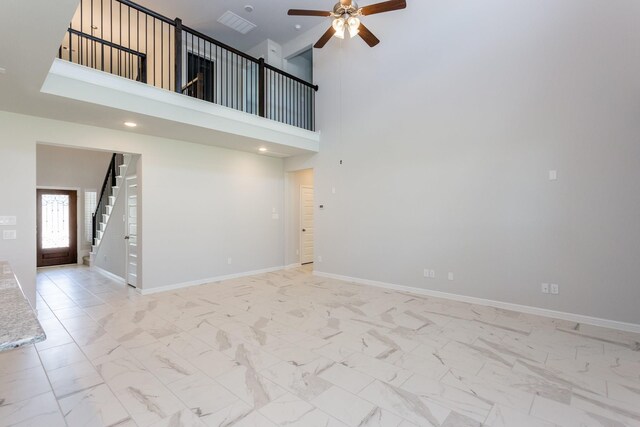 8506 Belfast Manor Ln, Richmond, TX 77407 - unfurnished living room featuring ceiling fan, stairs, a towering ceiling, light marble finish flooring, and recessed lighting
