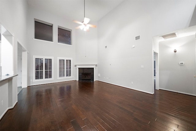 8014 Sports Haven Dr, Humble, TX 77346 - unfurnished living room with a towering ceiling, ceiling fan, a tile fireplace, and dark wood finished floors