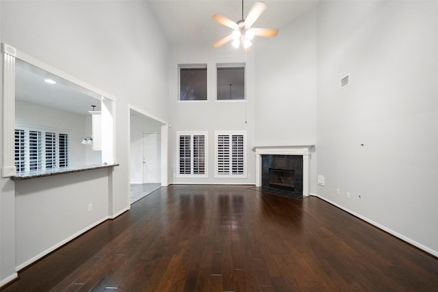 8014 Sports Haven Dr, Humble, TX 77346 - unfurnished living room with a towering ceiling, ceiling fan, a tile fireplace, and wood finished floors
