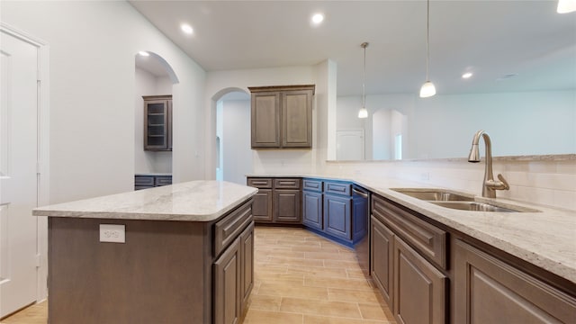 225 Sycamore, Lumberton, TX 77657 - kitchen featuring backsplash, arched walkways, light stone countertops, a kitchen island, and dishwasher