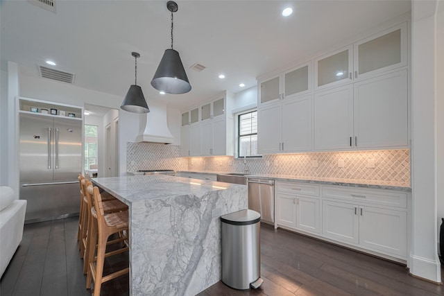 6525 Wharton St, Houston, TX 77055 - kitchen with appliances with stainless steel finishes, dark wood finished floors, white cabinets, tasteful backsplash, and recessed lighting