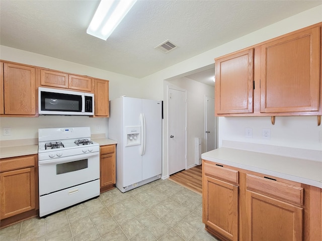 18403 Fair Grange Ln, Cypress, TX 77433 - kitchen with white appliances, light countertops, and light flooring