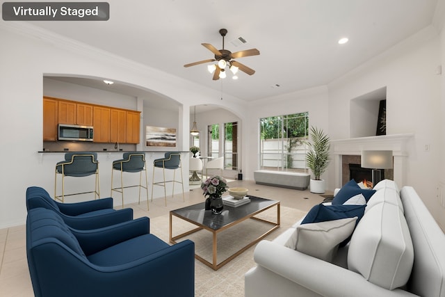 7615 Brae Acres Ct, Houston, TX 77074 - living room featuring ceiling fan, arched walkways, ornamental molding, recessed lighting, and a lit fireplace