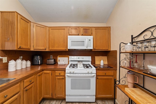3060 High Plains Dr, Katy, TX 77449 - kitchen with white appliances, vaulted ceiling, light wood finished floors, and butcher block countertops