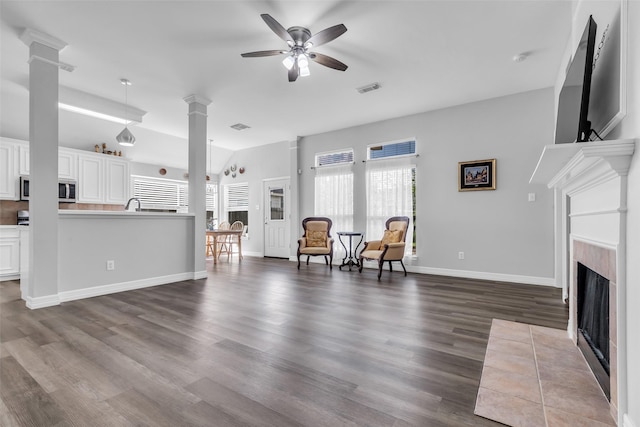 3731 Crescent Dr, Pearland, TX 77584 - living room featuring decorative columns, ceiling fan, plenty of natural light, and a fireplace with flush hearth